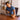 Man exercises arm on table while working on laptop in home office environment