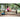Woman stretches with a foam roller on a park bench in a wooded area
