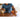 Person uses massage roller on arm near digital tablet in a bright room.